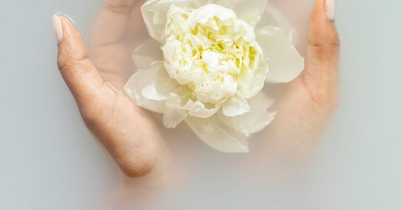 Allergy-Sensitive - Unrecognizable female with soft manicured hands holding white flower with delicate petals in hands during spa procedures